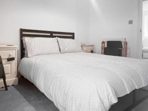 a bedroom with a large bed with a white comforter at Ernies in Haverigg