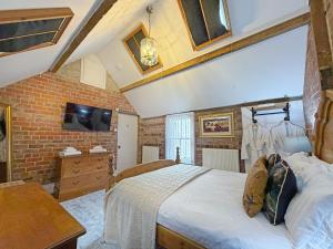 a bedroom with a bed and a brick wall at The Courtyard Cottage in Llangollen