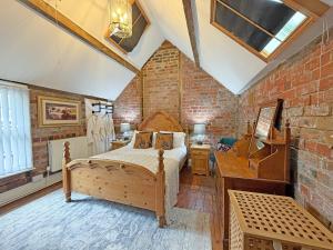 a bedroom with a bed and a brick wall at The Courtyard Cottage in Llangollen