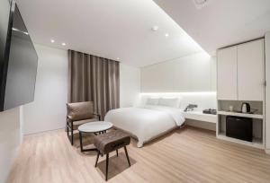 a hotel room with a bed and a table and chair at 서초 Hotel Brick in Seoul