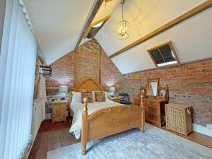 a bedroom with a bed and a brick wall at The Courtyard Cottage in Llangollen +5 photos