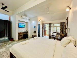 a bedroom with a large bed and a living room at Peravel Beach Holiday Home in Candolim