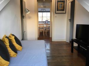 a room with a bed with yellow pillows and a table at Casa de Cima in Lisbon