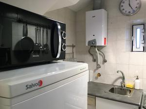 a microwave sitting on top of a kitchen counter at Casa de Cima in Lisbon +23 photos