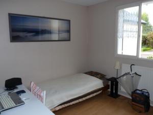a bedroom with a bed and a tv on the wall at Chambre lit simple in Saint-Herblain