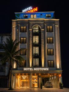 a hotel with a sign on top of it at Hotel Midtown in Surat