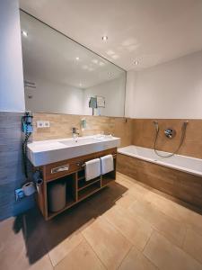 ein Badezimmer mit großem Spiegel, Waschbecken und Badewanne in der Unterkunft Landhaus Beckmann in Kalkar + 54 Fotos