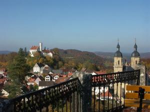 Blick auf eine Stadt mit einer Bank und Gebäuden in der Unterkunft Die kleine Pension in Gößweinstein