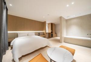 a bedroom with a large white bed and a table at 서초 Hotel Brick in Seoul +12 photos