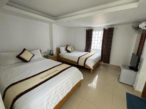 a hotel room with two beds and a television at Europa Hotel in Da Lat +102 photos
