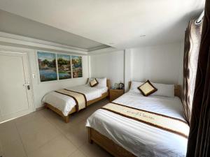 a bedroom with two beds and a window at Europa Hotel in Da Lat