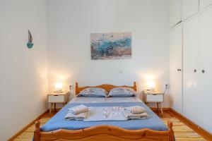 a bedroom with a bed with blue sheets and pillows at Hippocrates' House in Amorgos