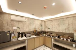 a kitchen with a counter with aasteryasteryasteryasteryasteryasteryasteryasteryastery at Hotel Midtown in Surat