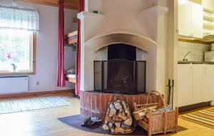 a living room with a brick fireplace with a tv at Stunning Home In Eksjö With Kitchen in Eksjö