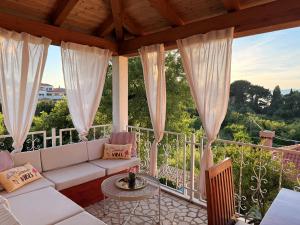a living room with a white couch on a balcony at House Glasnović in Cavtat