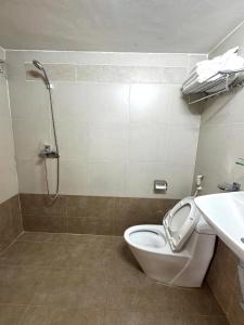 a bathroom with a toilet and a shower and a sink at Europa Hotel in Da Lat