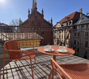 a table and chairs on a balcony with coffee cups at Carillon Aparthotel - Keystone Collection, opened December 2025 in Riga