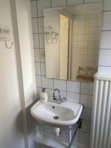 a bathroom with a white sink and a mirror at Di'Mami House in Avenhorn