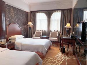 a hotel room with two beds and a flat screen tv at Grand Palace Hotel - Grand Hotel Management Group in Guangzhou
