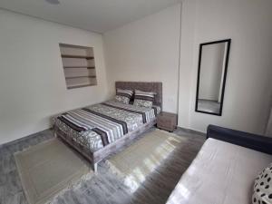 a bedroom with a bed and a mirror at Dar Elghalia in Houmt Souk
