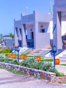 a house with orange pots in front of it at Elafonisi Paradise with Parking, WiFi, - Walking Distance to the Beach in Elafonisi