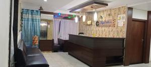 a lobby with a bar and a leather couch in a room at Royal shades kodihali in Bangalore