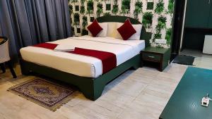 a bedroom with a large bed with red pillows at Royal shades kodihali in Bangalore