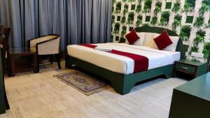a bedroom with a bed and a table and a chair at Royal shades kodihali in Bangalore