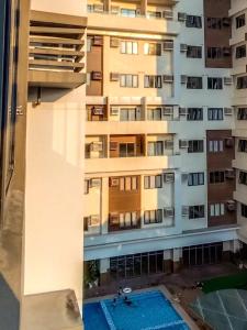 an apartment building with a swimming pool in front of it at Be Residences Studio in Cebu City