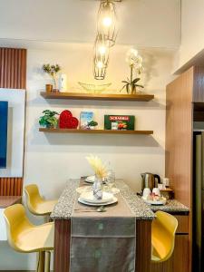 a kitchen with a table with yellow chairs at Be Residences Studio in Cebu City