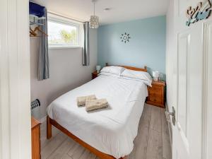 a bedroom with a bed with white sheets and a window at No 4 Hickling Chalet - Uk51729 in Scratby