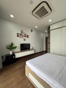 a bedroom with a bed and a flat screen tv at SQUIRRELHOME District8 in Ho Chi Minh City