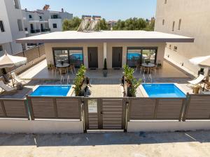 a building with two swimming pools on a balcony at Olivio 4 Seasons Villas in Nea Moudania
