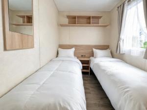 two beds are lined up in a room at The Medway - Uk51004 in Eastchurch