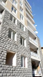 een hoog stenen gebouw met een stenen muur bij Happy Apartment 7 in Tbilisi City