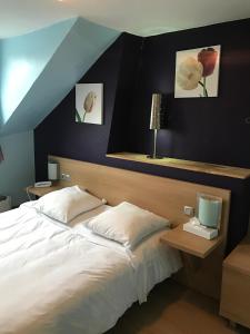 - une chambre avec un lit et deux photos sur le mur dans l'établissement Tipi, à Paris