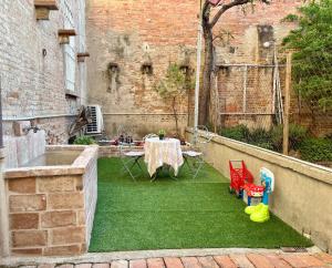 a patio with a table and chairs on the grass at Casa in Centro con Giardino in Imola