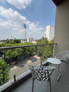 a balcony with a table and a chair on a building at SQUIRRELHOME District8 in Ho Chi Minh City