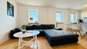 a living room with a couch and a table at CBlue "Admiralsloge - Nauticus" in Warnemünde +30 photos