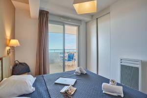 a bedroom with a bed with a view of the ocean at Résidence Odalys Le Lotus Blanc in Le Barcarès +82 photos