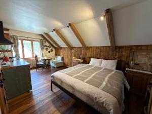 a bedroom with a large bed and a kitchen at Zelta Apelsīna Rezidences in Kuldīga