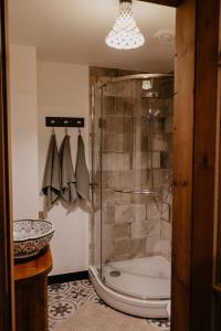 a bathroom with a shower with a glass shower stall at Zelta Apelsīna Rezidences in Kuldīga