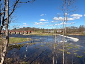 a view of a river with a bridge in the background at Zelta Apelsīna Rezidences in Kuldīga +6 photos