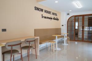 a showroom with stools and a counter with a sign on the wall at SNOW HOUSE Buriram in Buriram