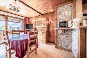 a kitchen and dining room with a table and chairs at La Pointe des Mattes in La Chapelle-dʼAbondance