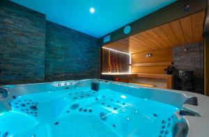 a bath tub in a bathroom with blue lighting at Wellness Vila Žakovce s bazénom in Veľká Lomnica