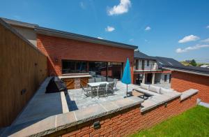 a brick building with a patio with a table and chairs at Wellness Vila Žakovce s bazénom in Veľká Lomnica