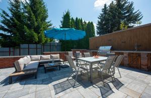a patio with a table and chairs and an umbrella at Wellness Vila Žakovce s bazénom in Veľká Lomnica