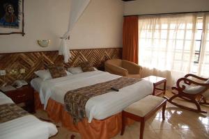 ein Hotelzimmer mit zwei Betten und einem Fenster in der Unterkunft Seasons Elementaita Country Lodge in Nakuru + 16 Fotos