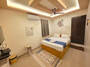a small room with a bed and a television at Vijaya Lodge in Vadalūr